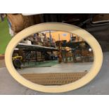 AN OVAL CREAM PAINTED WOODEN FRAMED MIRROR