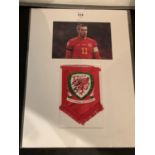 A PICTURE OF WALES INTERNATIONAL AND REAL MADRID PLAYER GARETH BALE WITH A SIGNED WELSH PENDANT IN A