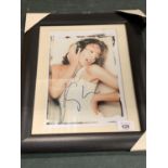 A FRAMED AND SIGNED PHOTOGRAPH OF KYLIE MINOGUE