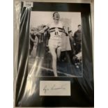 A MOUNTED BLACK AND WHITE PHOTOGRAPH OF ROGER BANNISTER AND HIS AUTOGRAPH COMPLETE WITH