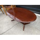 AN OVAL MAHOGANY COFFEE TABLE