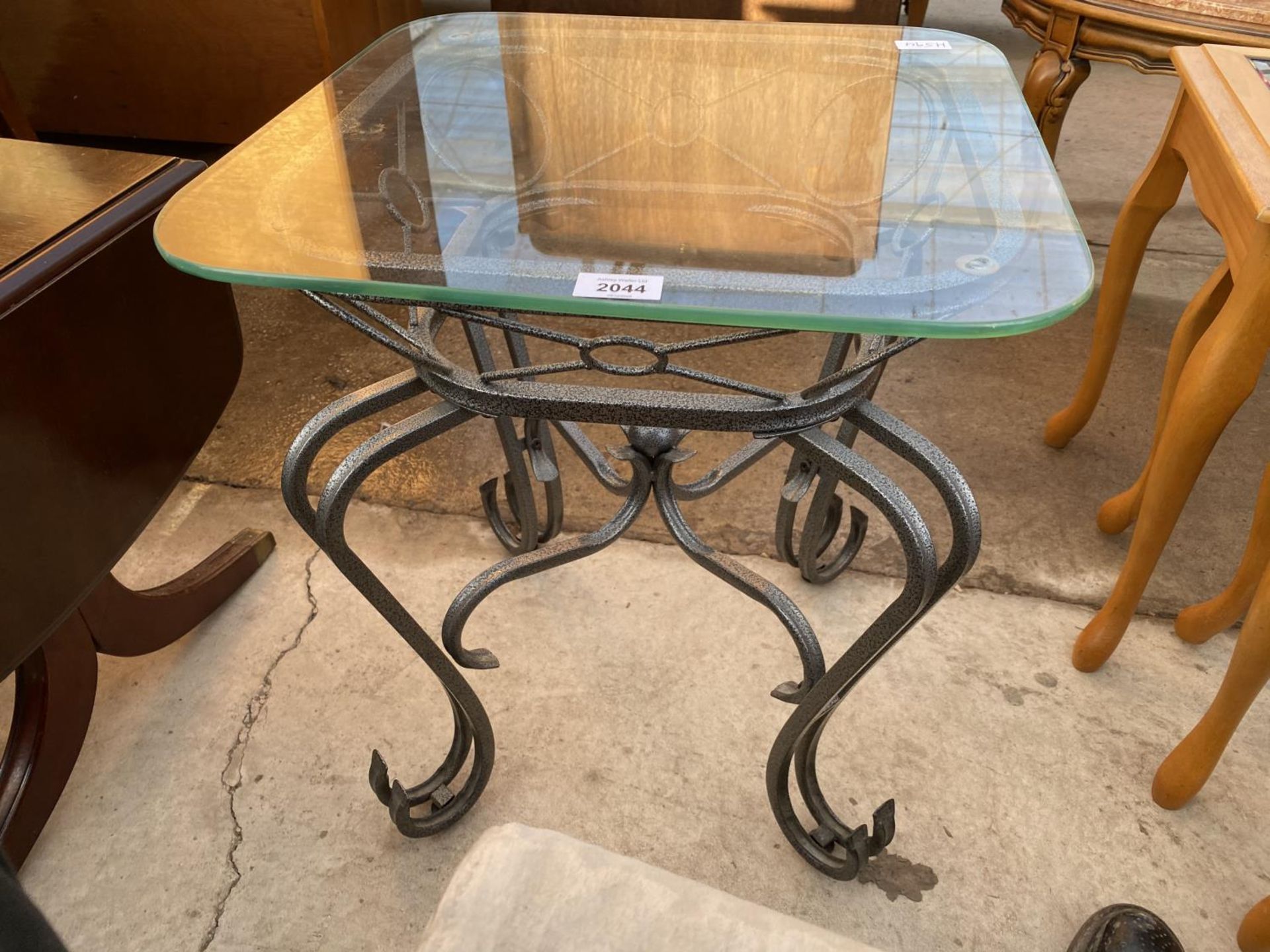 A SMALL WROUGHT IRON OCCASIONAL TABLE WITH GLASS TOP
