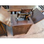 A VINTAGE SINGER SEWING MACHINE IN AN OAK CABINET