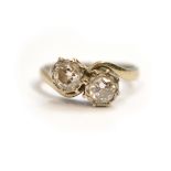 An 18ct H/M white gold two stone diamond set ring, the two round brilliant cut diamonds total approx