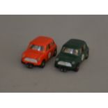 2 unboxed vintage Scalextric C76 Austin Mini Cooper slot car models, one in green, RN '9', the other