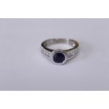 A sapphire & diamond ring, stamped 750, the round sapphire measures approx 1.00ct, princess cut