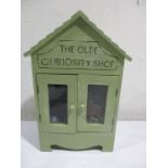 A diorama "The Olde Curiosity Shop" with wooden building set up as an antique shop with miniature