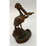 A hand carved miniature dolls house stick/ umbrella stand in the form of a stork with a snake in its