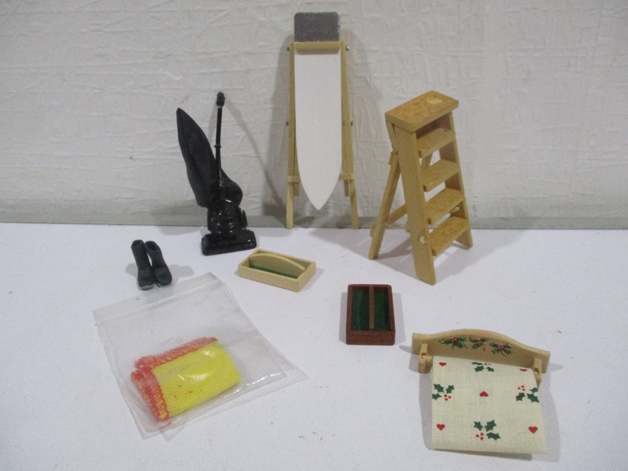 A collection of miniature dolls house kitchen items including an ironing board, step ladder,