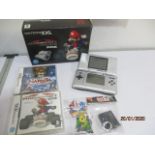 A boxed original Nintendo DS with Mario Kart and Narnia games etc