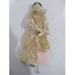 An antique articulated wooden "peg" doll with period costume