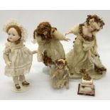 Four china dolls/figures in period and ethereal costumes along with a wedding cake