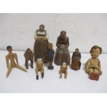 A collection of carved wooden figures along with modern peg dolls