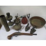 A collection of paraffin burners and lamps, copper two handled bowl, large brass shell case etc