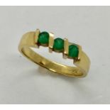 An 18ct gold emerald three stone ring marked CK, 3.6g