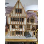 A large Tudor style dolls house with a selection of dolls house furniture