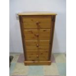 A narrow pine chest of four drawers