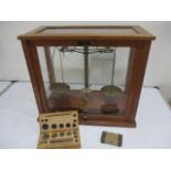 A cased set of apothecary scales , along with weights