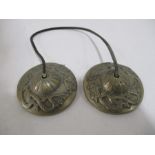 A pair of Tibetan cymbals decorated with dragons on leather strap
