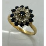An 18ct gold ring with 13 sapphires and 8 diamonds in a wagon wheel design.