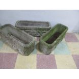 A set of three large concrete troughs