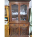 A mahogany display cabinet on cupboard with two drawers and carved detailing.