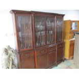 A dark wood break fronted displayed cabinet, with cupboard and four drawers