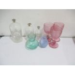 Three etched graduated glass bottles along with other glassware