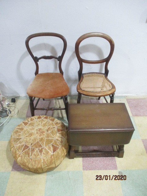 Two chairs along with a small drop leaf coffee table and a vintage pouffe