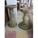 A decorative concrete bird bath along with one other