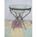 A brass round occasional table with glass top and bowl under