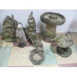 A collection of concrete garden ornaments including a gnome, birdbath etc.