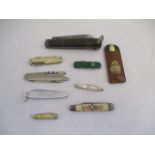 A vintage army knife marked A. Ibbett along with a collection of folding pocket knives