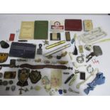 A collection of miscellaneous items including badges, patches, whistle, shell casings, stamps,