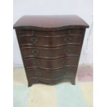 A serpentine chest of four drawers with brush slide