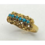 An unmarked Victorian gold ring set with a row of turquoise