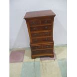 A miniature yew wood chest of eight drawers