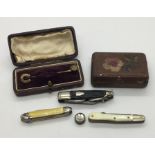 An airmans miniature compass along with three small penknives and two tie pins