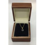 A 14ct gold pendant set with a sapphire on a gold coloured chain