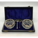 Two cut glass salts with hallmarked silver rims, cased