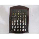 A collection of thimbles including some silver in display case