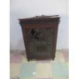 An Edwardian mahogany wall mounted corner cupboard