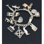 A continental silver charm bracelet with with various charms, 84.9g