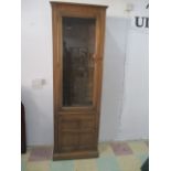 An Ercol Golden Dawn narrow display cabinet with cupboard under