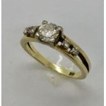 A 14ct gold diamond ring, the central stone measuring approx 6mm diameter (0.8ct) with two