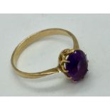 An unmarked gold ring set with an oval amethyst