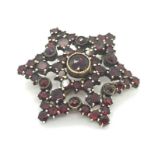 A Victorian star shaped brooch set with garnets