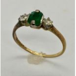 An 18ct gold and platinum Art Deco design ring with emeralds and diamonds.