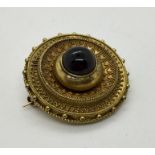 A Victorian mourning brooch with cabochon garnet