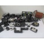 A collection of various cameras, lenses and flashes including Canon, Kodak, Panasonic, Zenit etc
